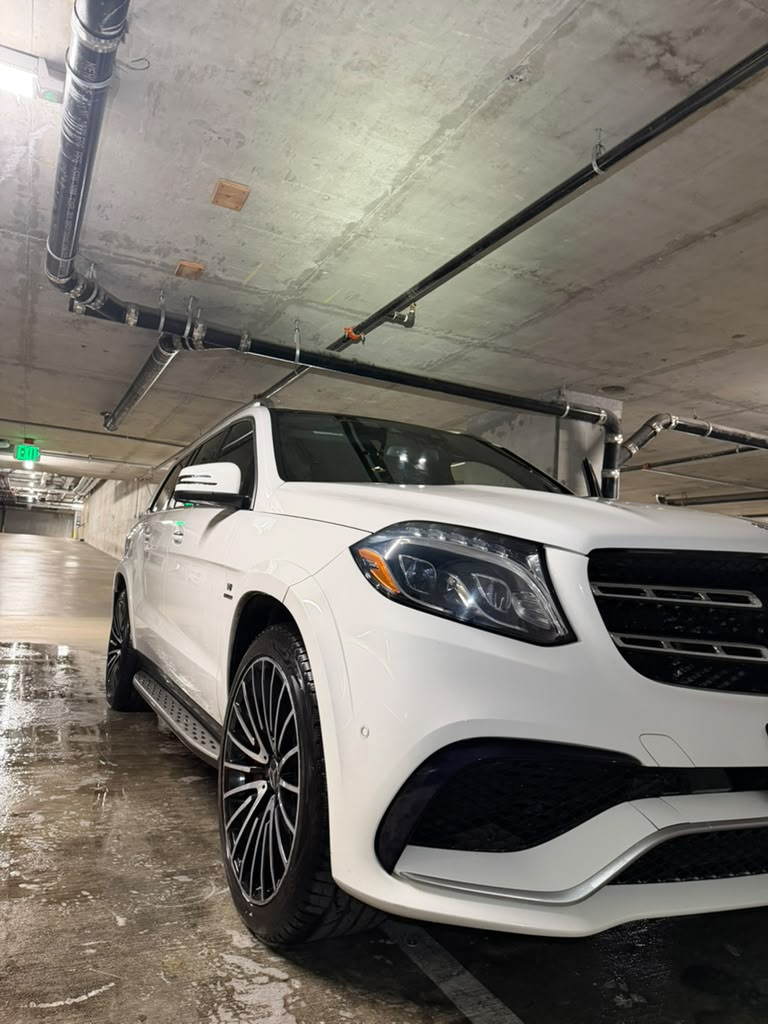 Professional detailing team cleaning engine bay and rims